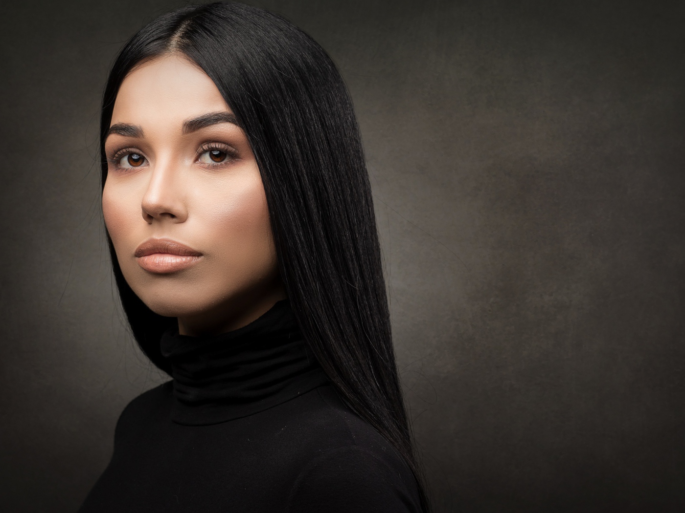 Молодая длинноволосая шатенка на сером фоне