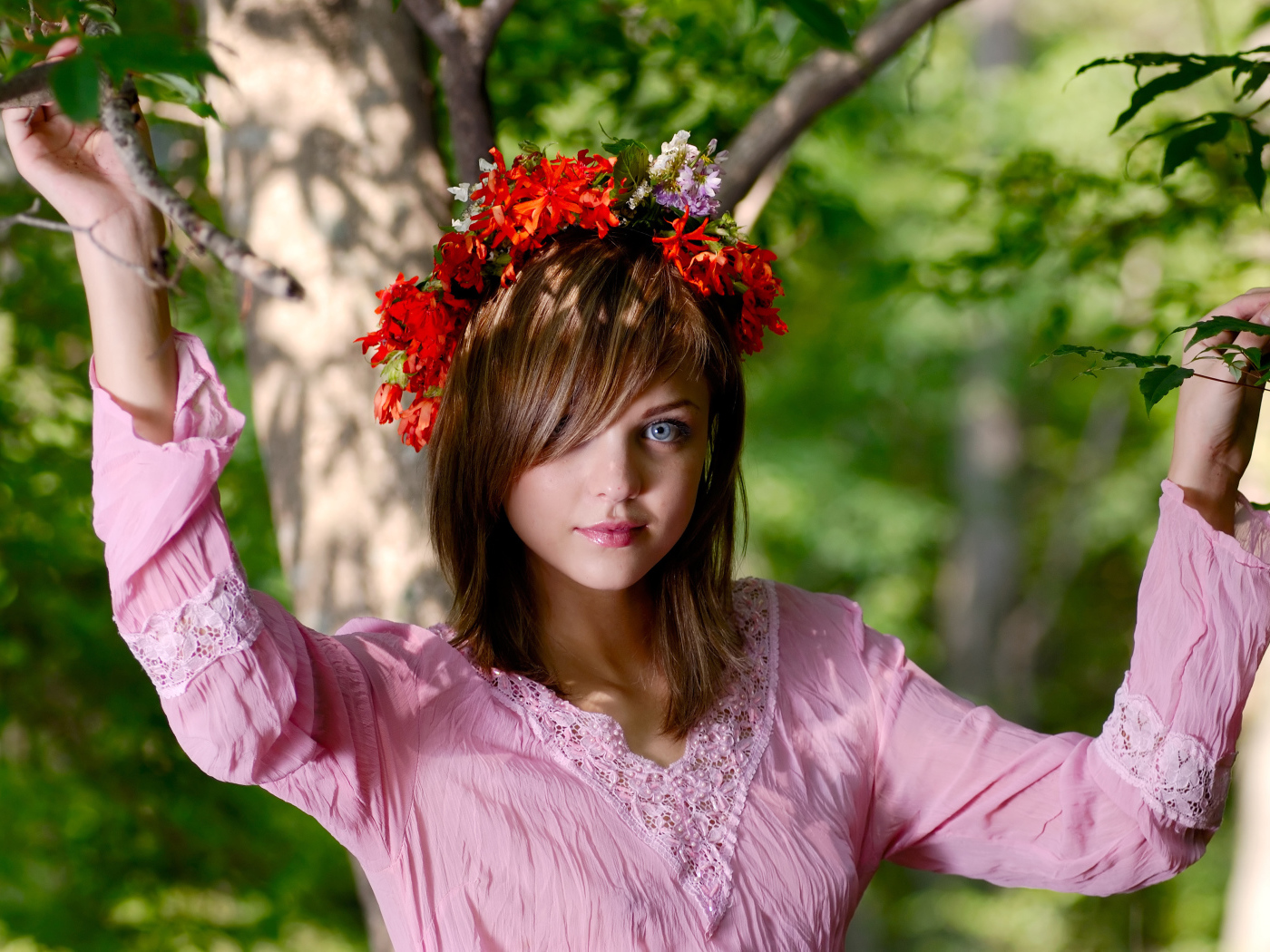Молодая милая голубоглазая девушка с венком на голове у дерева