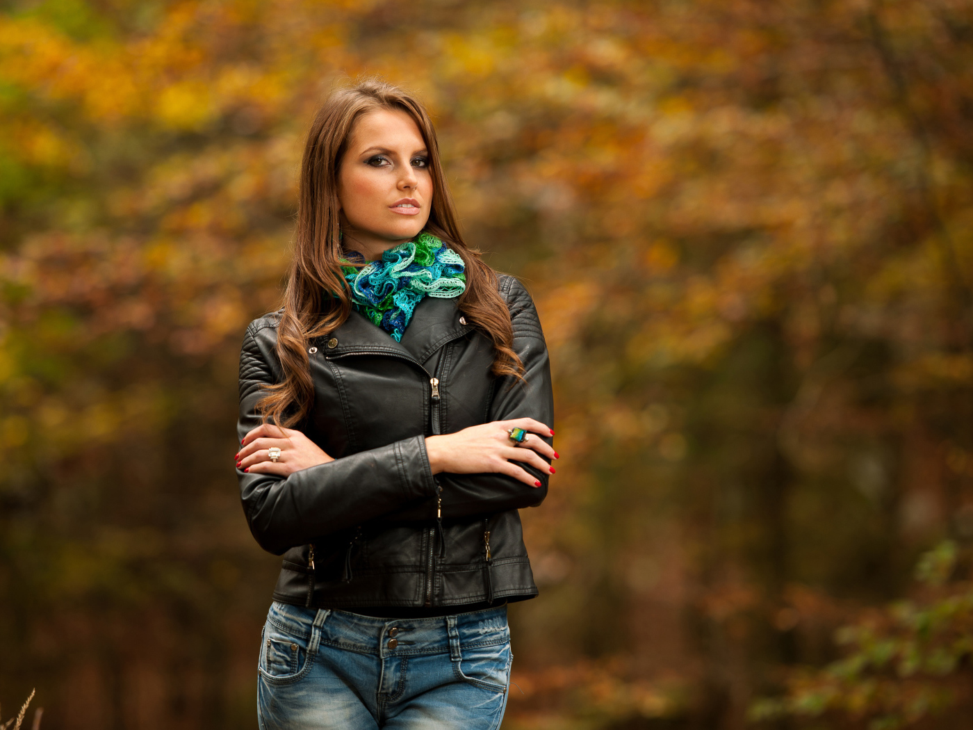 Молодая девушка в черной кожаной куртке  в парке