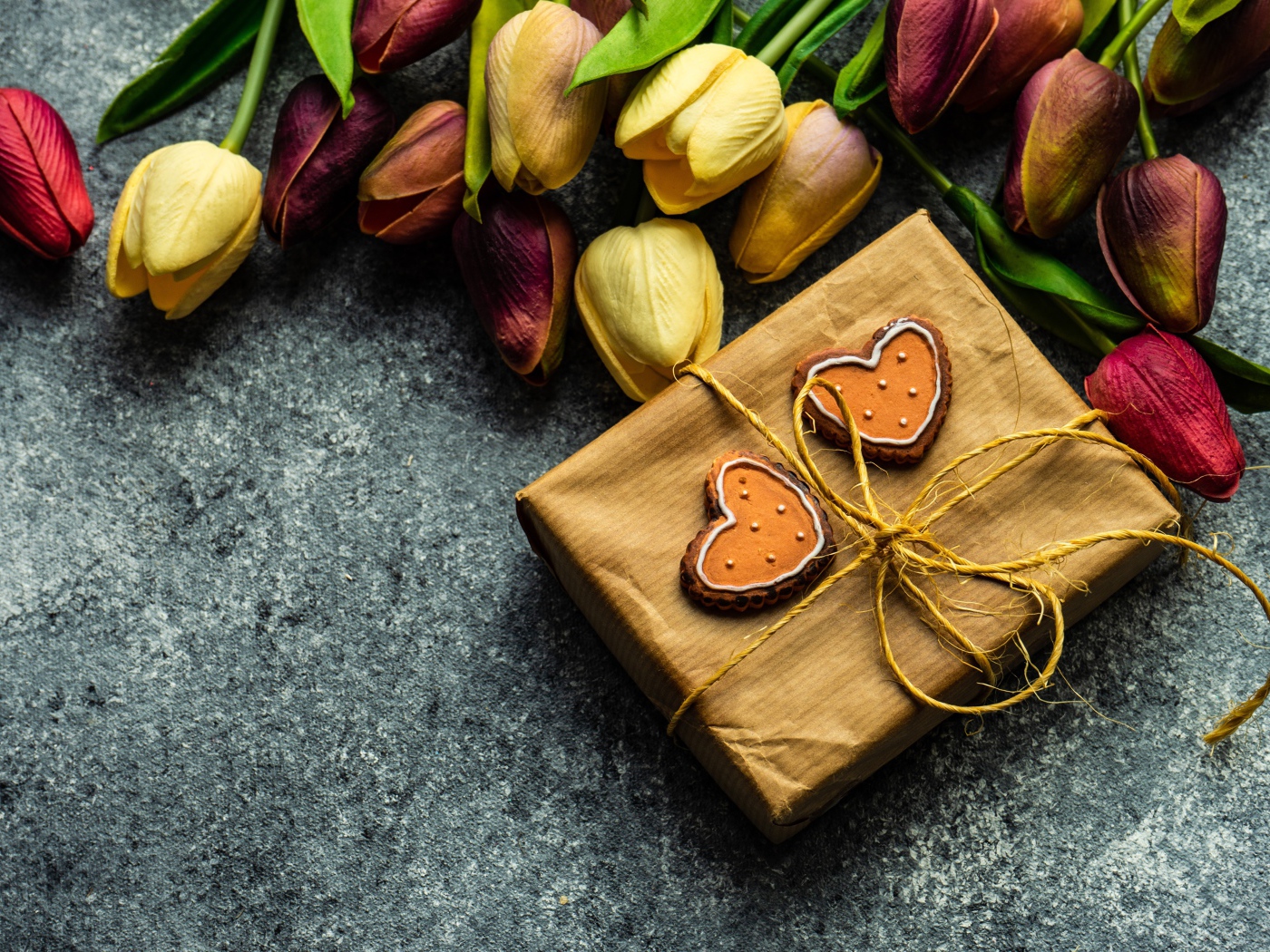 Подарок с букетом тюльпанов на сером столе