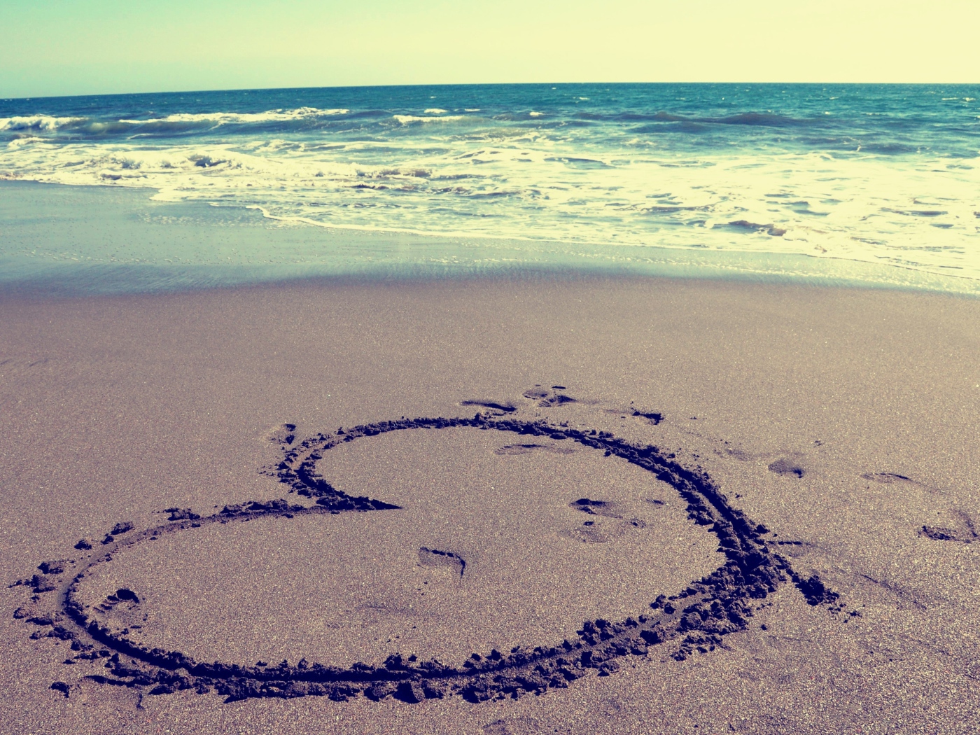 Большое сердце на мокром песке на пляже