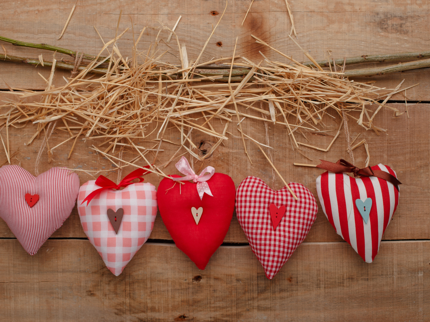 Тканевые сердечки на столе с сеном и веткой