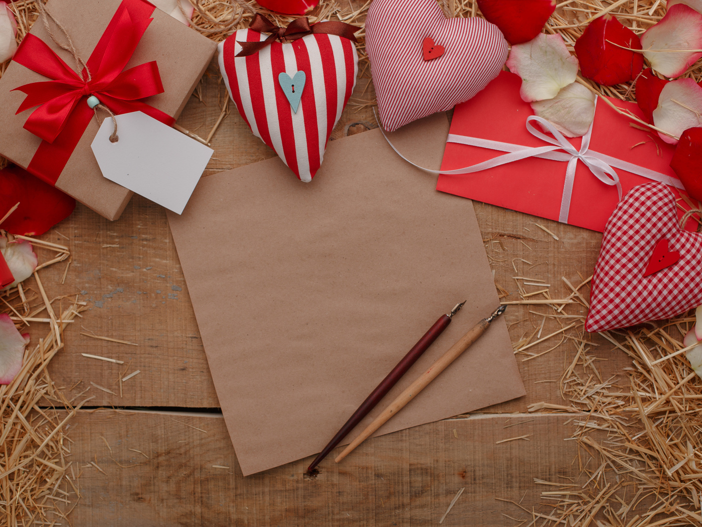 Сердечки из ткани на столе с бумагой и подарками 