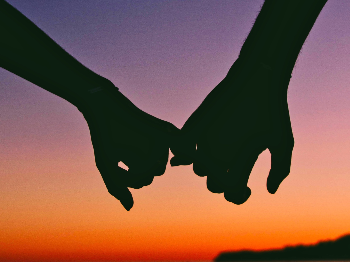 Hands of a couple in love at sunset