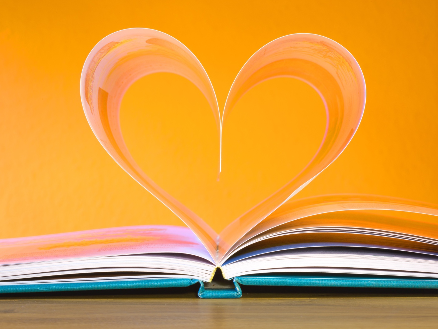 Сердце из страниц книги на желтом фоне