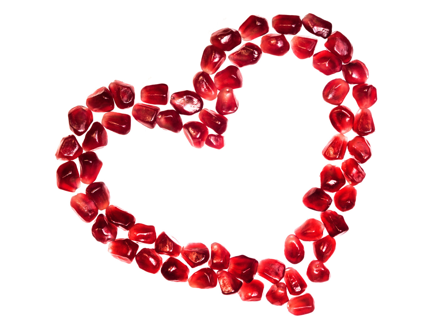 Сердце из гранатовых зерен на белом фоне
