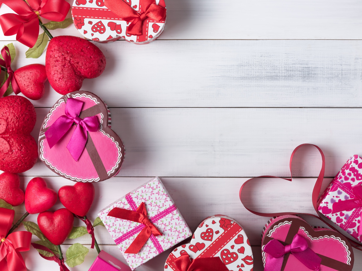 Много подарочных коробок в форме сердца на сером столе 