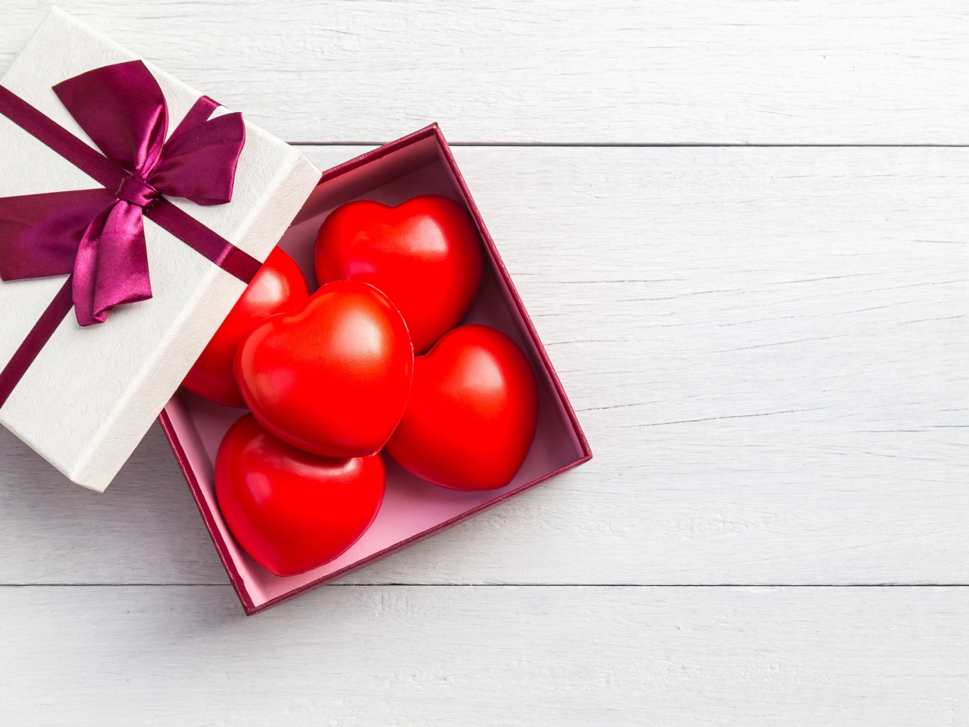 Красные сердечки в коробке на сером фоне