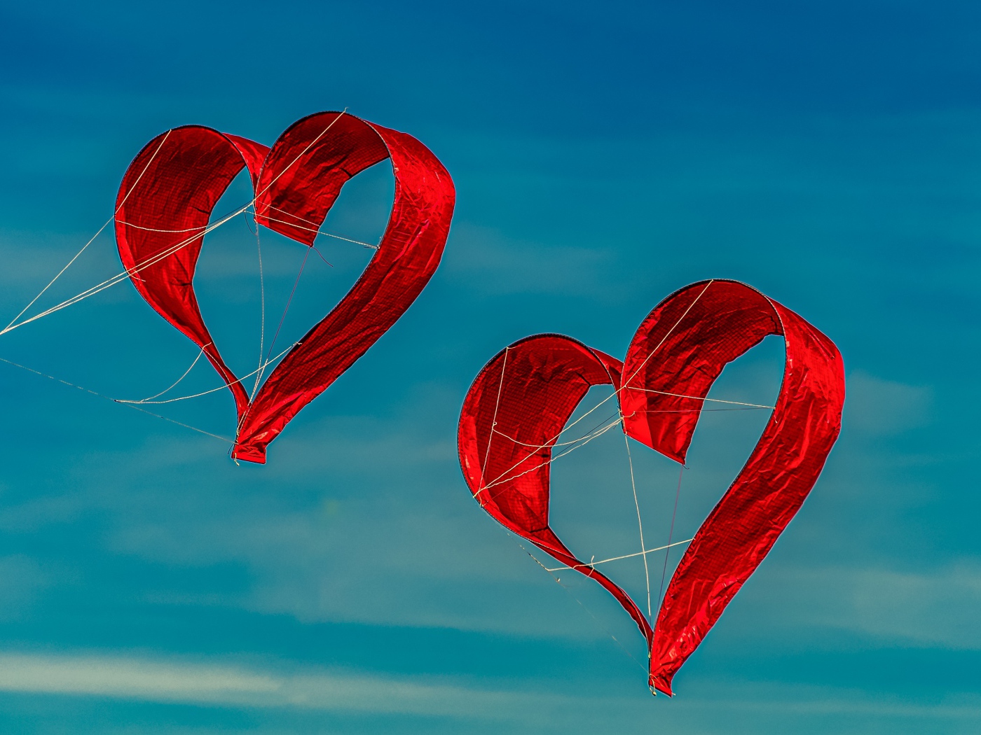 Два воздушных змея в форме сердца в небе