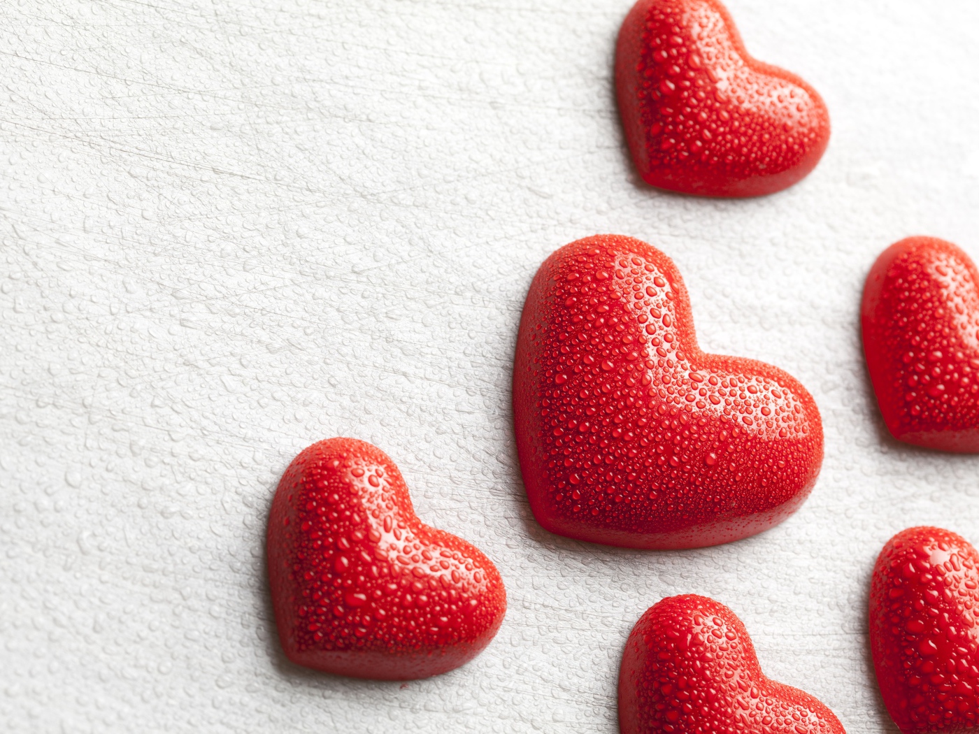 Мокрые красные сердечки на белом фоне