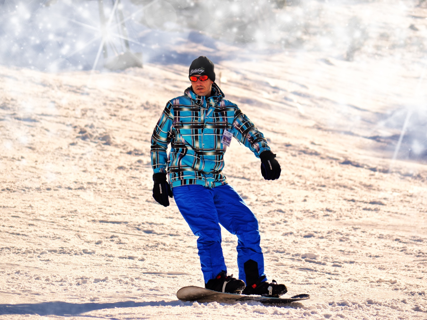 A man snowboarder drives down the mountain