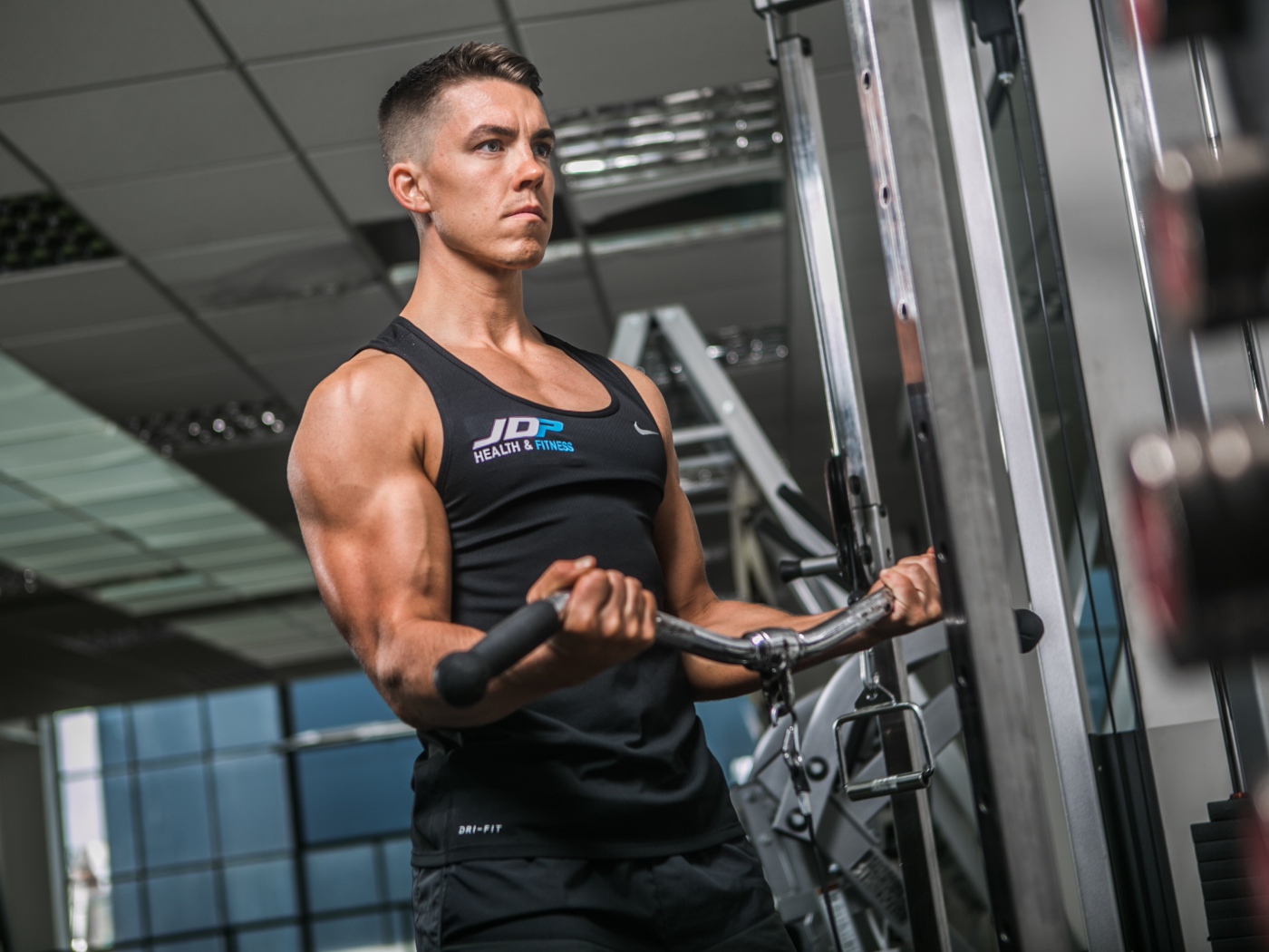 Накаченный мужчина занимается на тренажере в спортзале