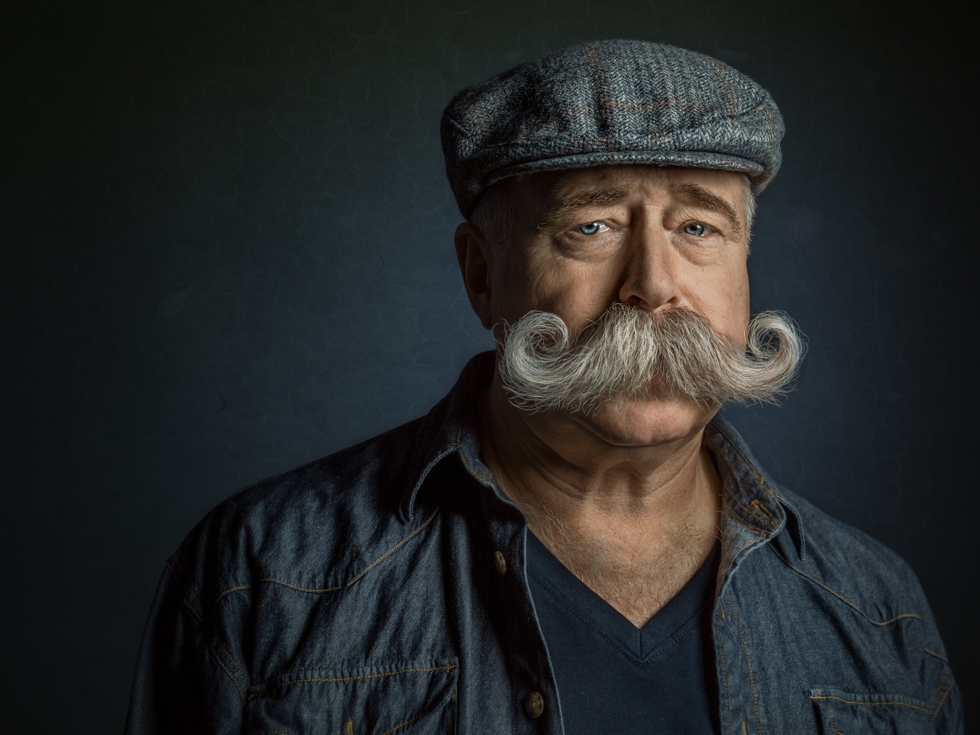 Мужчина в кепке с большими усами на лице 