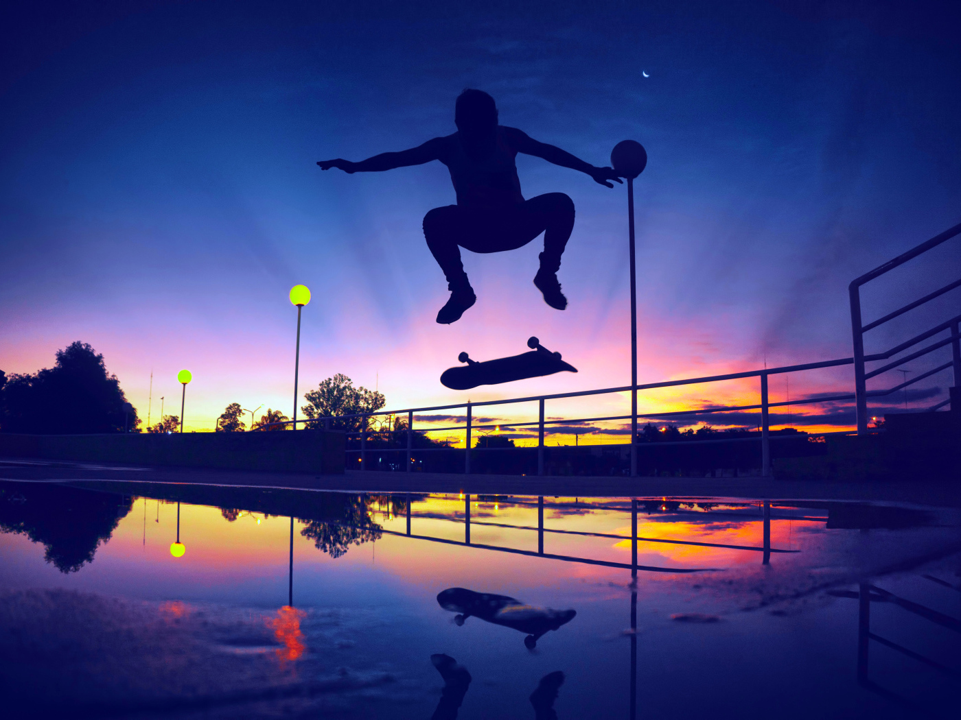 Парень прыгает на скейте на фоне заката