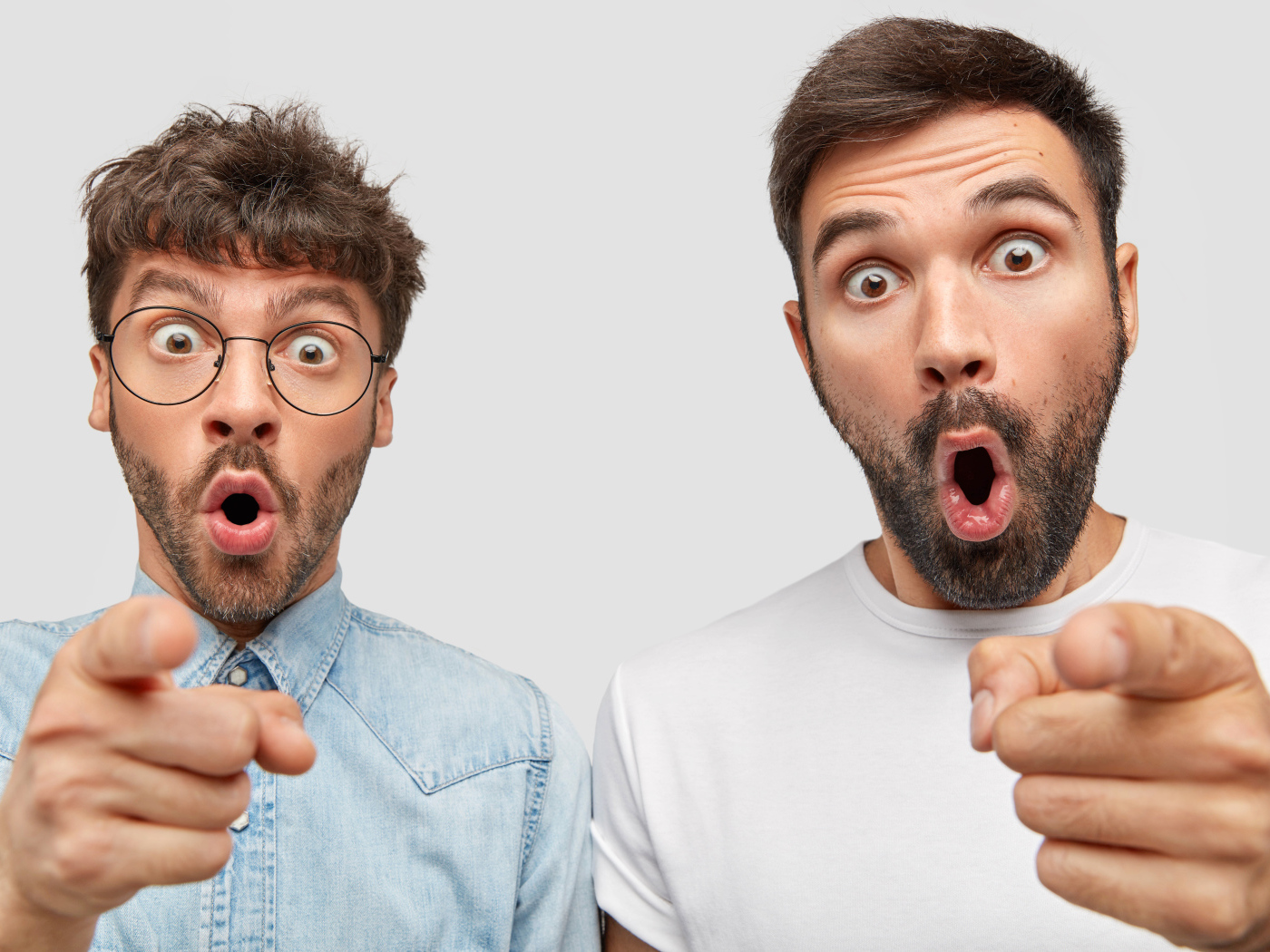 Два удивленных мужчины на сером фоне