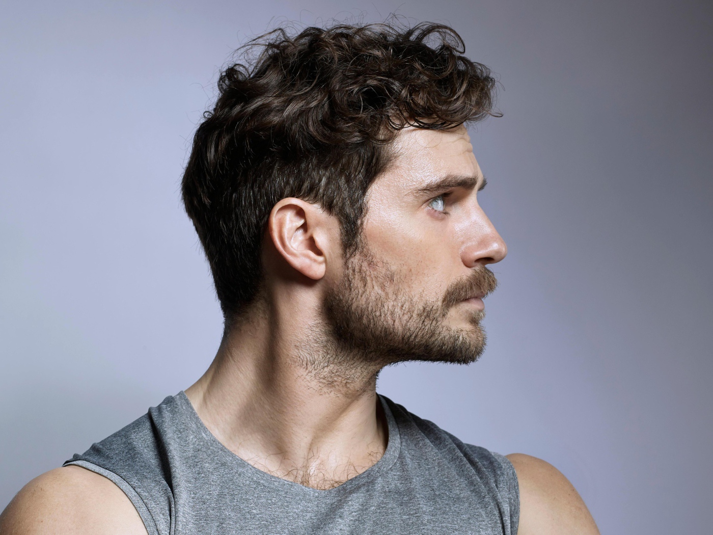 Красивый мужчина, актер Генри Кавилл на сером фоне