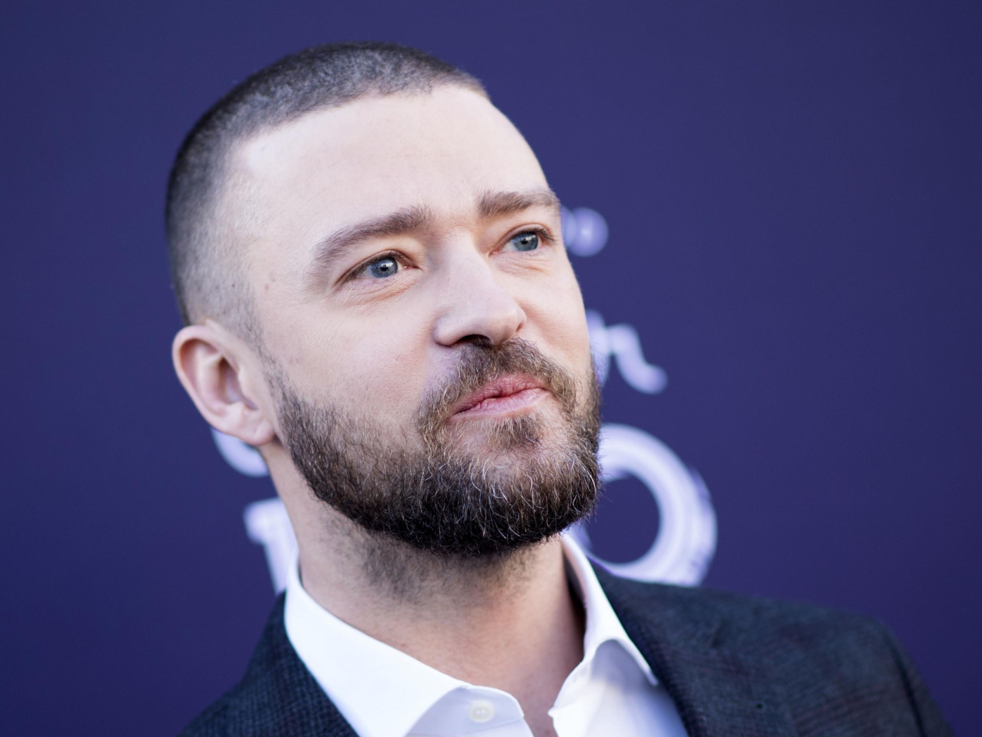 Лицо голубоглазого актера Джастина Тимберлейка на синем фоне