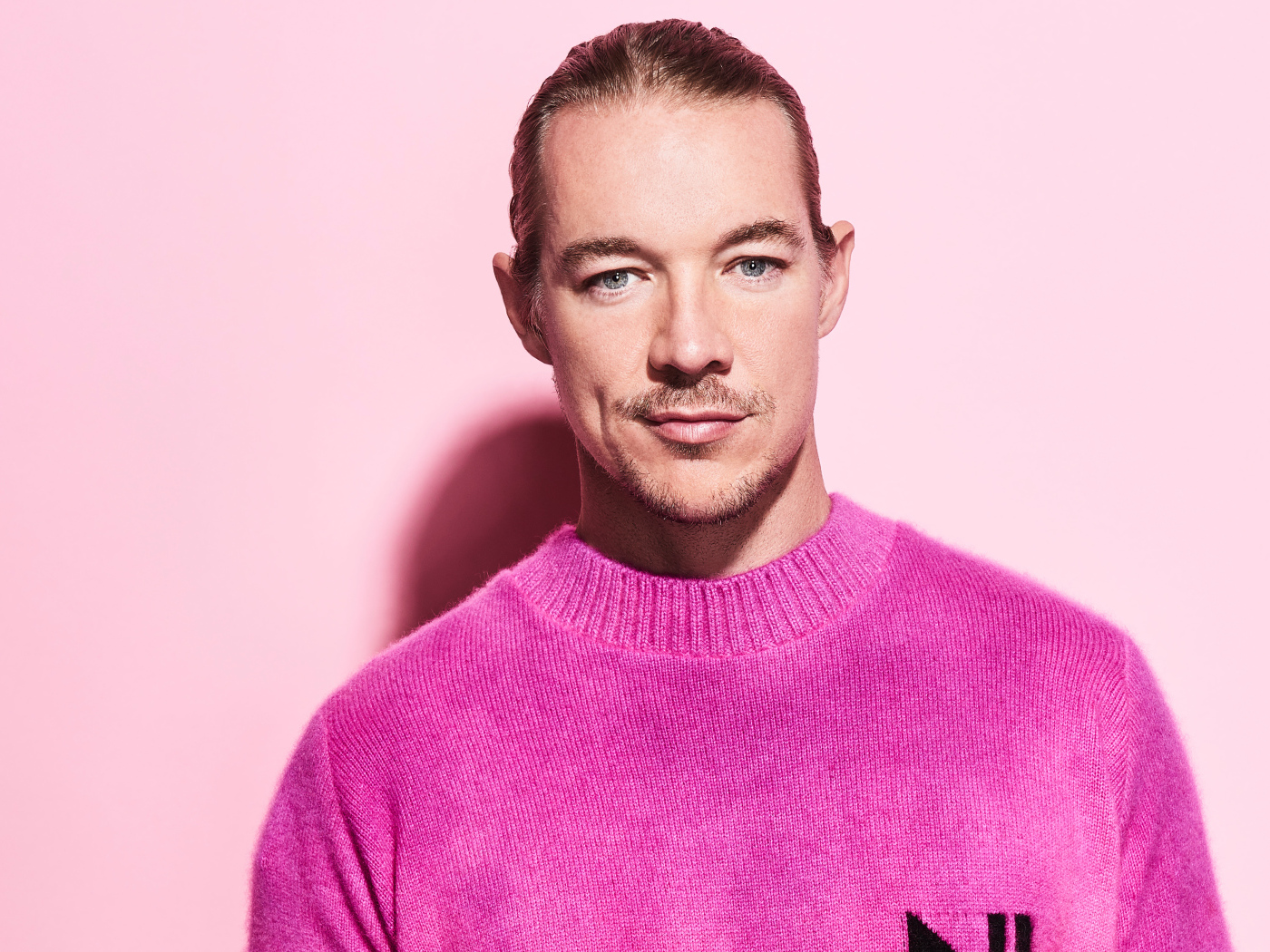 Американский диджей Дипло на розовом фоне