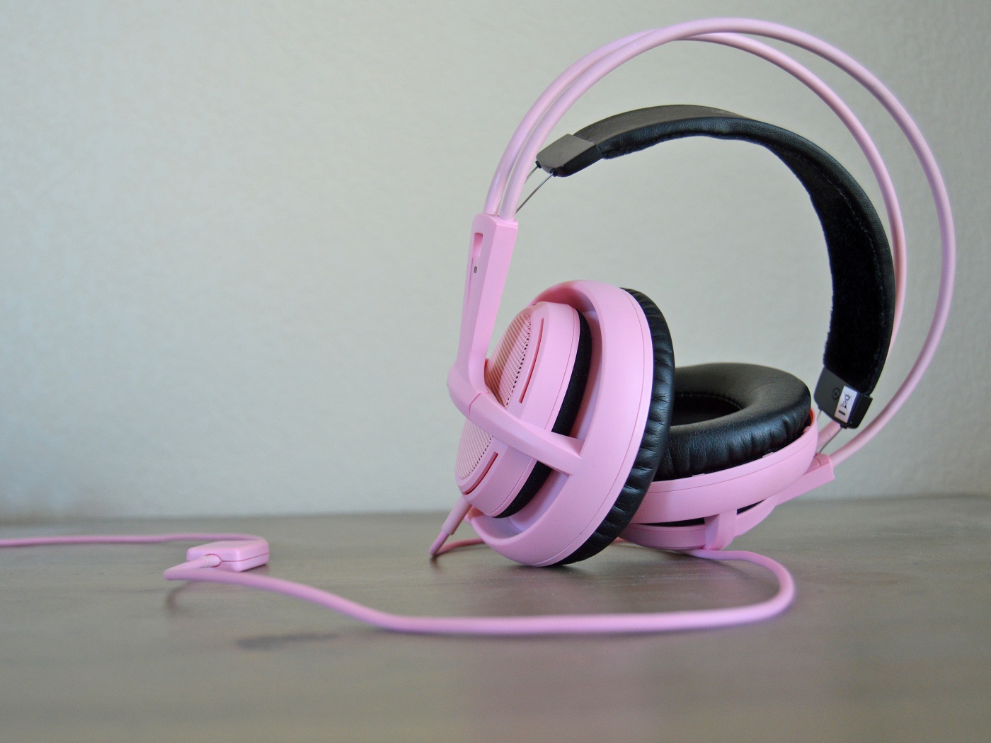 Большие розовые наушники на столе 