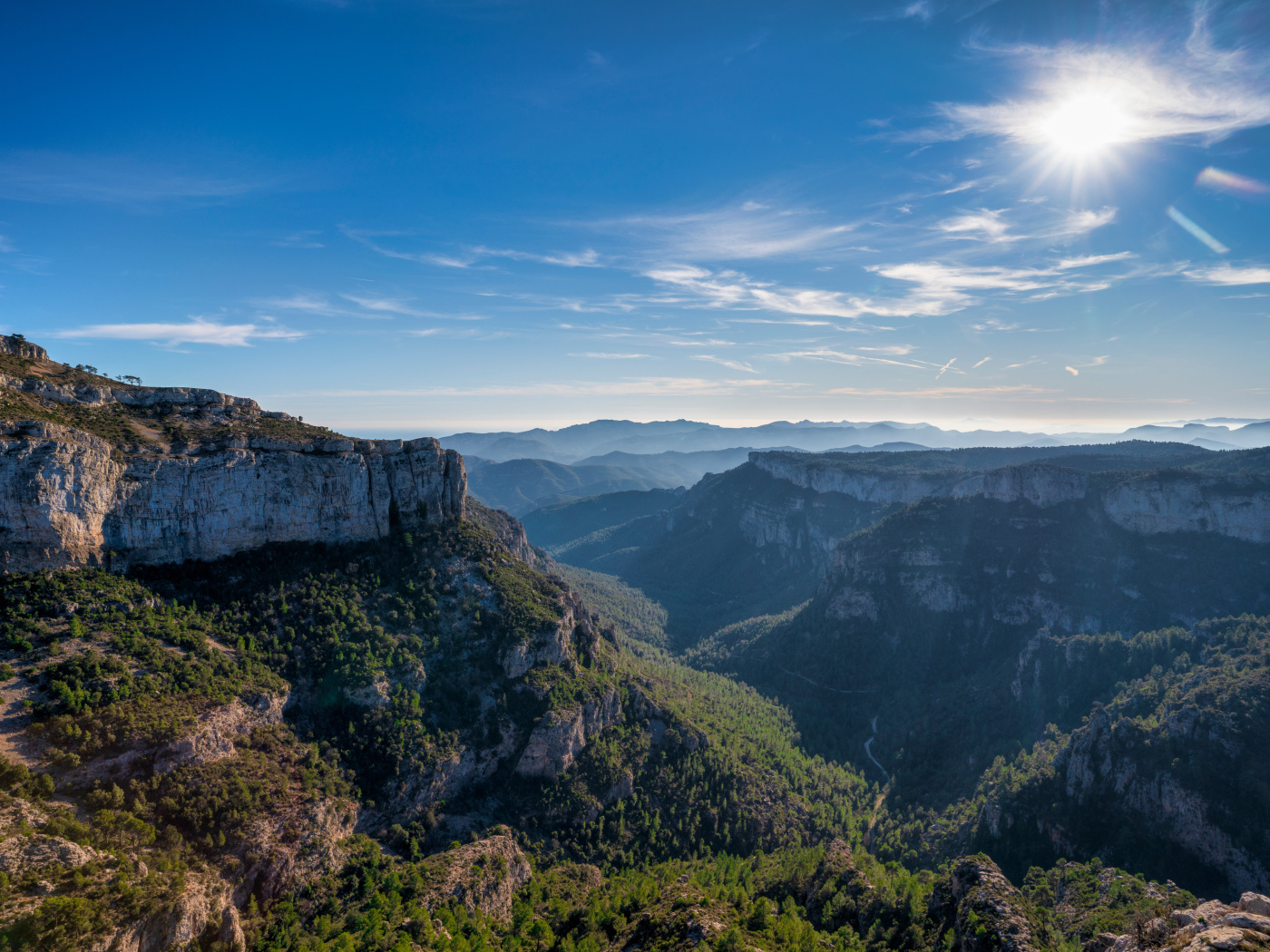Яркое солнце в голубом небе над высокими горами 