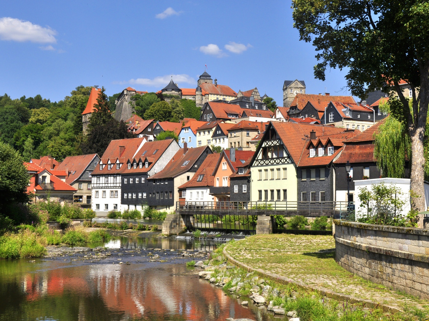 Много домов у пруда на фоне голубого неба