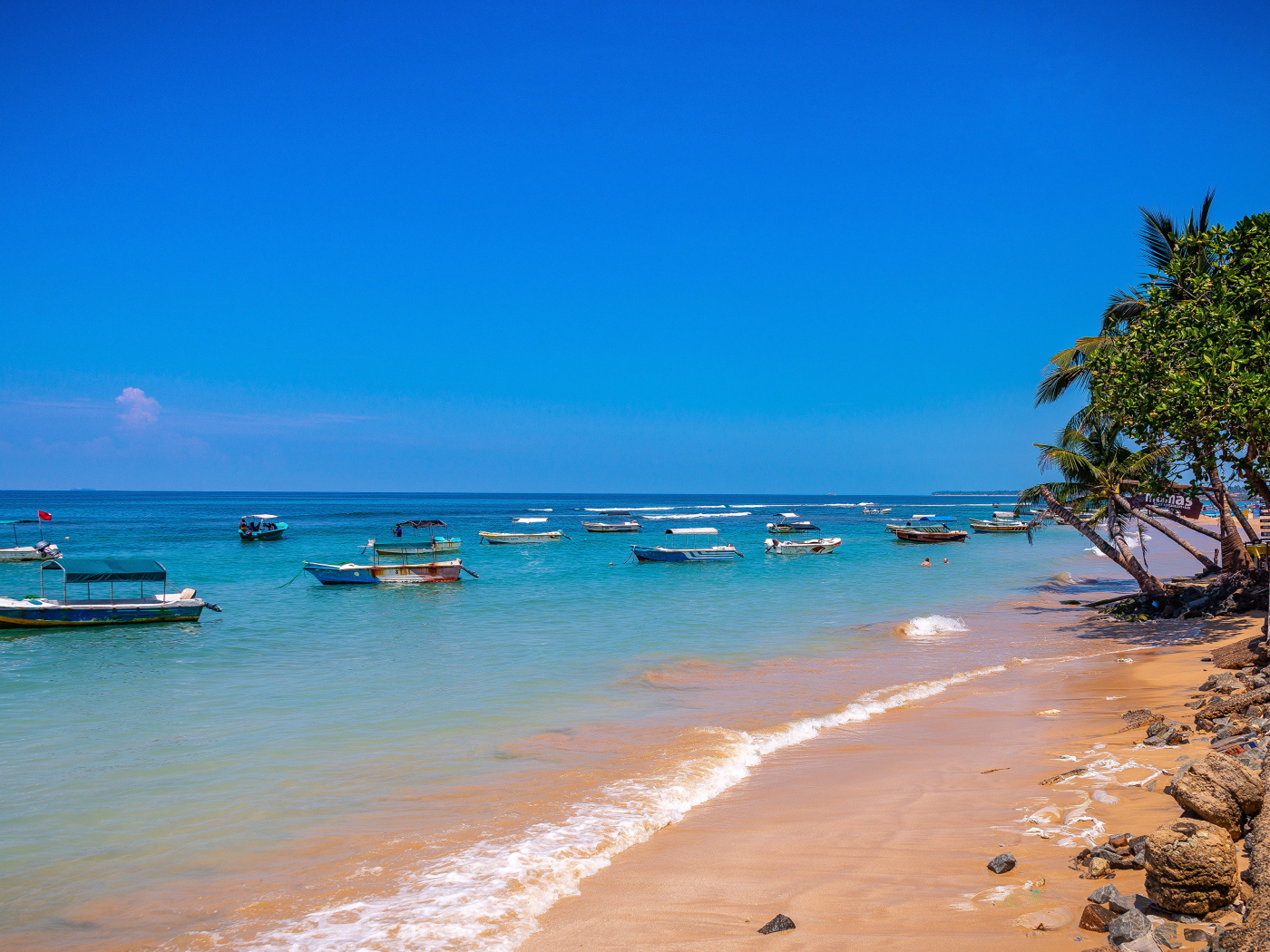 Лодки на берегу тропического пляжа на фоне голубого неба 