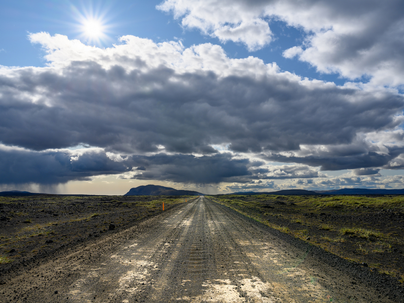 Длинная дорога под голубым солнечным небом с белыми облаками летом