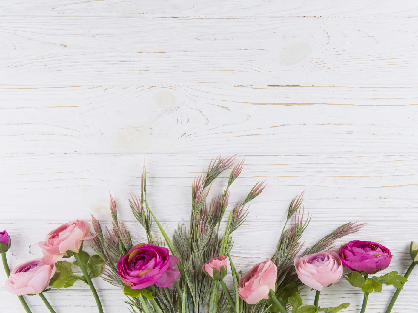 Букет разноцветных лютиков на белом столе