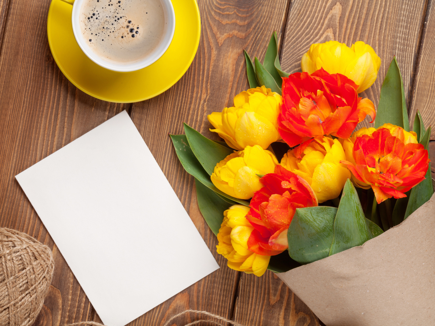 Букет тюльпанов на столе с листом бумаги и чашкой кофе