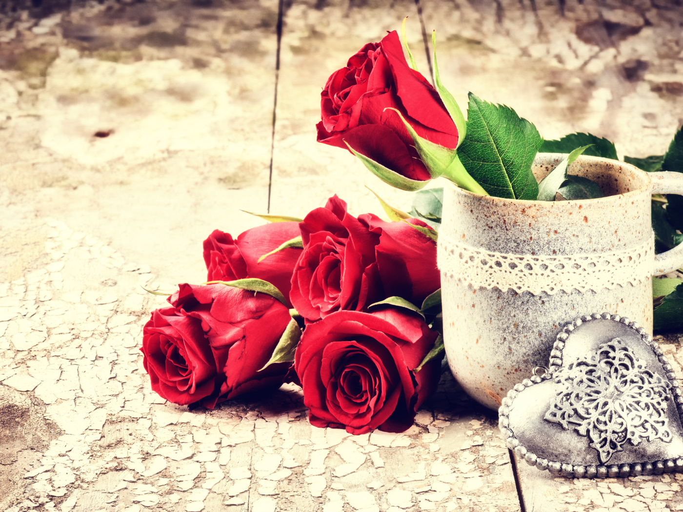 Красные розы на столе с кружкой и сердцем 