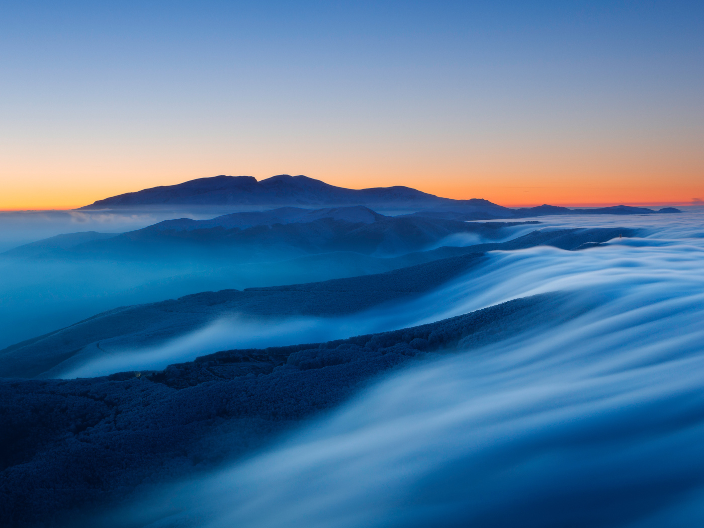 Туман покрывает высокие горы на рассвете 