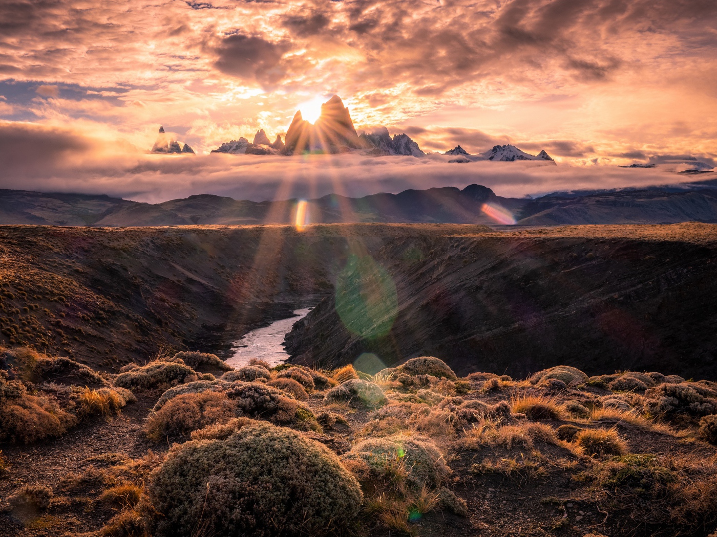 Лучи яркого солнца пробиваются сквозь вершину горы на рассвете 