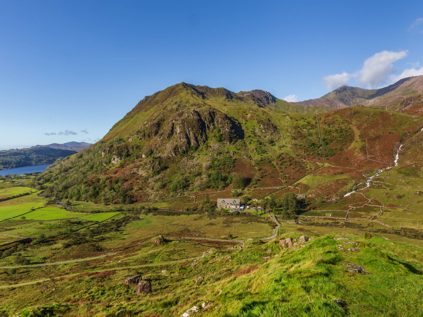 Вид на покрытую зеленью гору под голубым небом