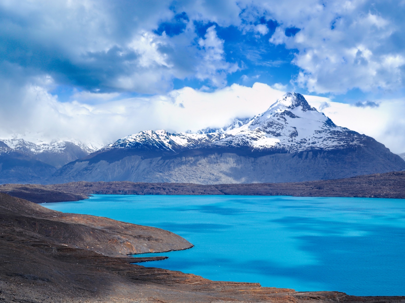 Вид на заснеженную вершину горы у голубого озера 
