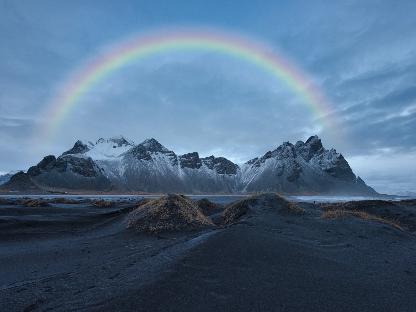 Радуга в небе над высокими горами