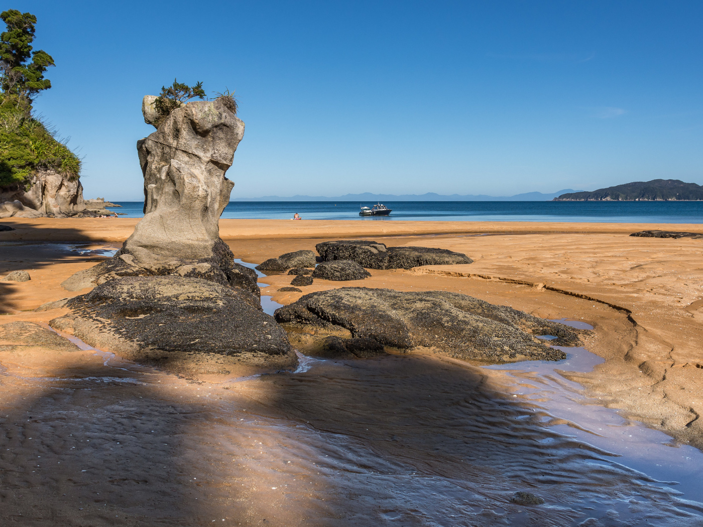 Большие камни на берегу на мокром песке у моря летом 