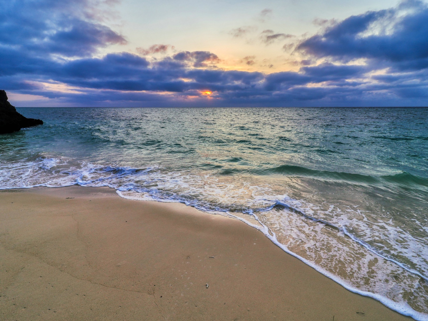 Голубая морская вода на песке на закате солнца