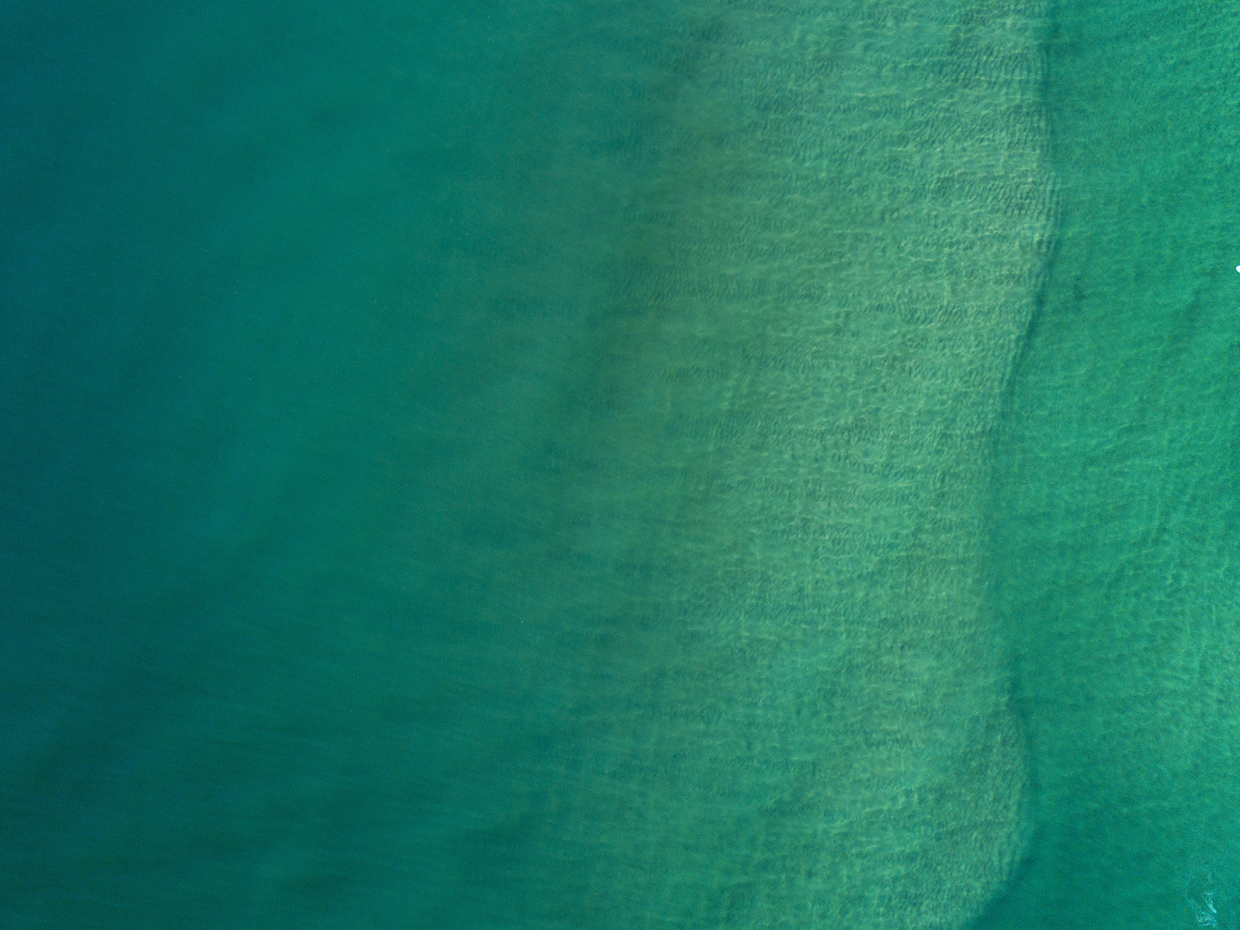 Вид сверху на спокойную голубую гладь океана