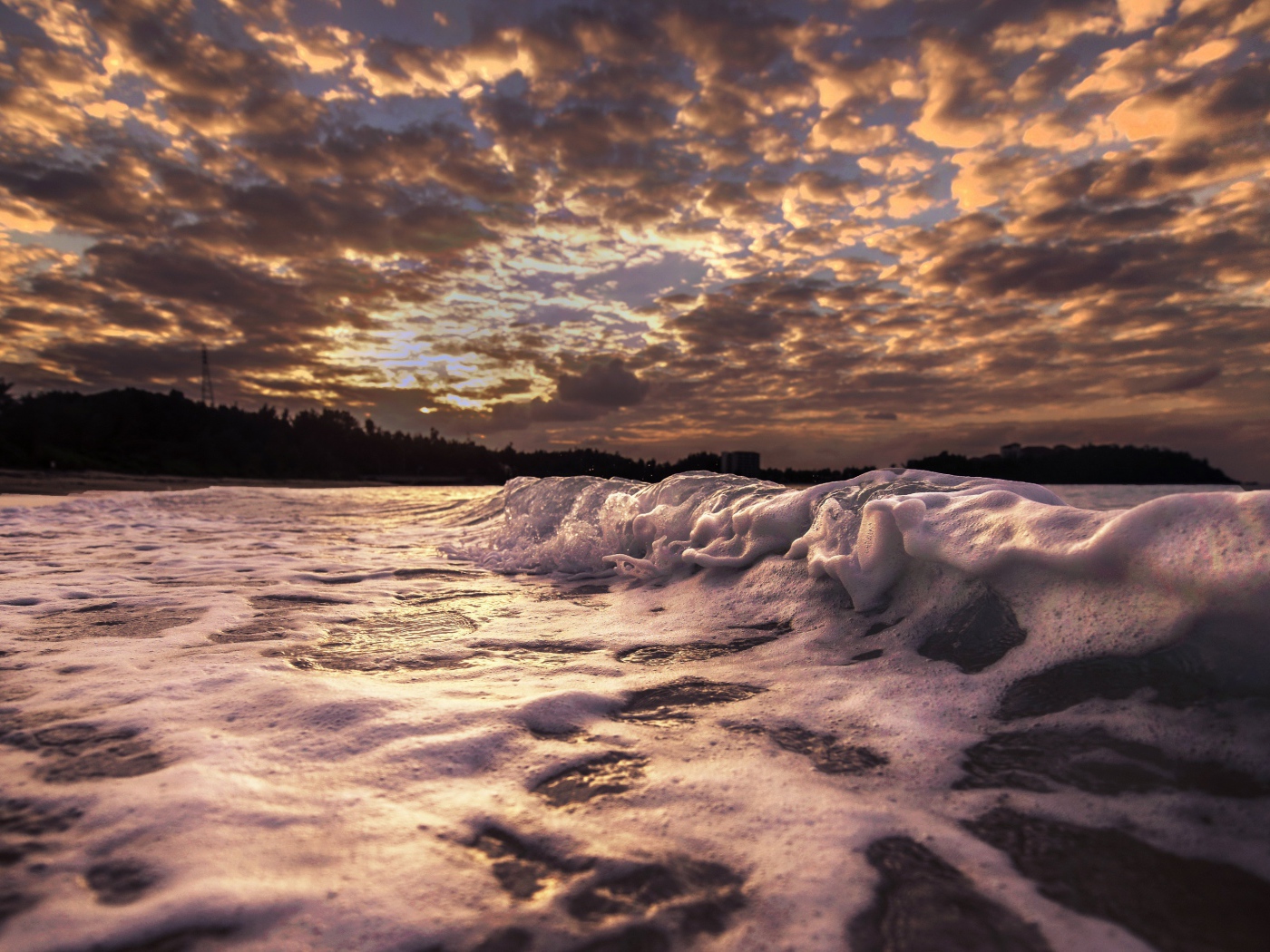Белые волны на песке на рассвете 