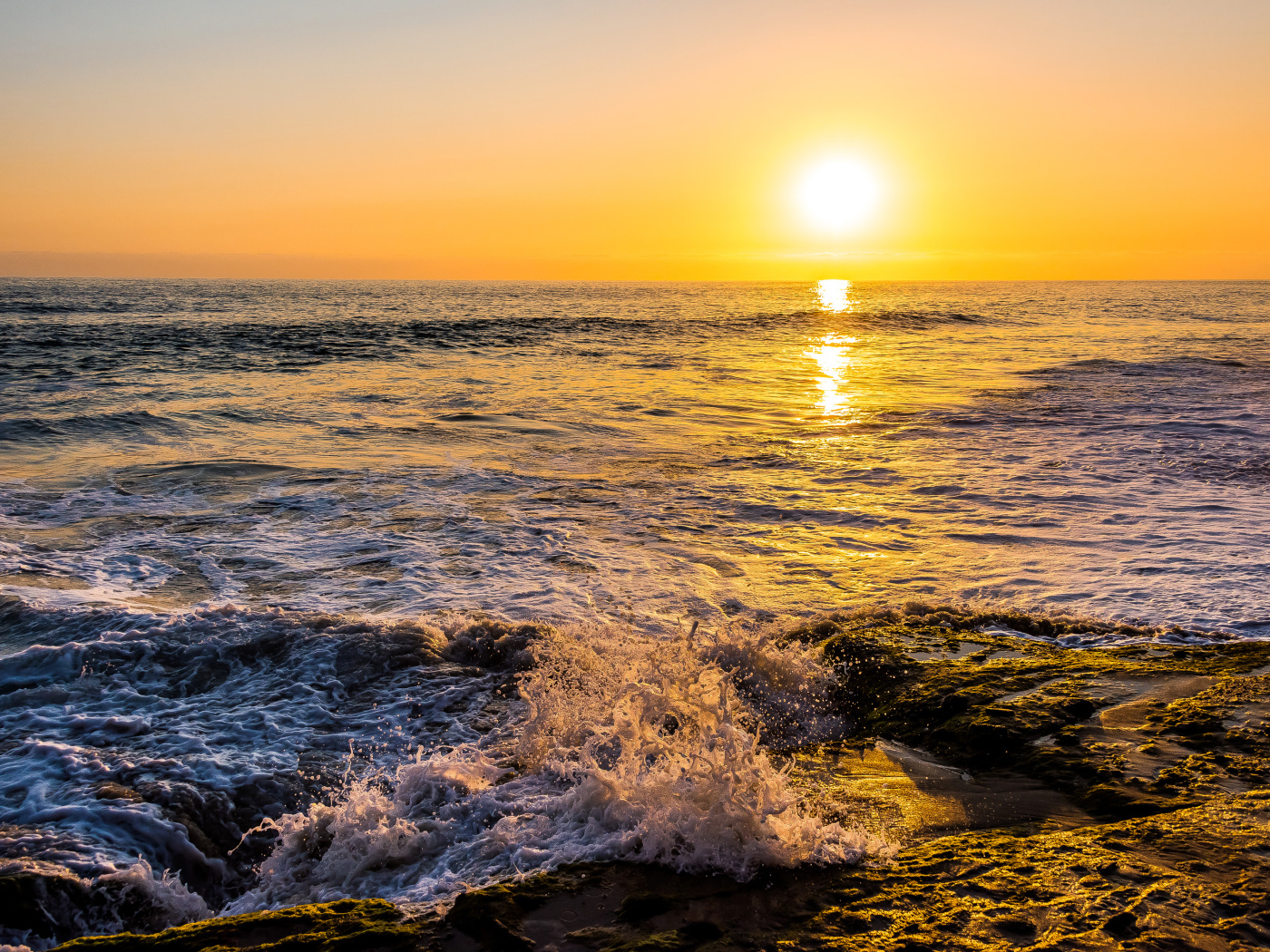 Белые волны бьются о берег на закате 