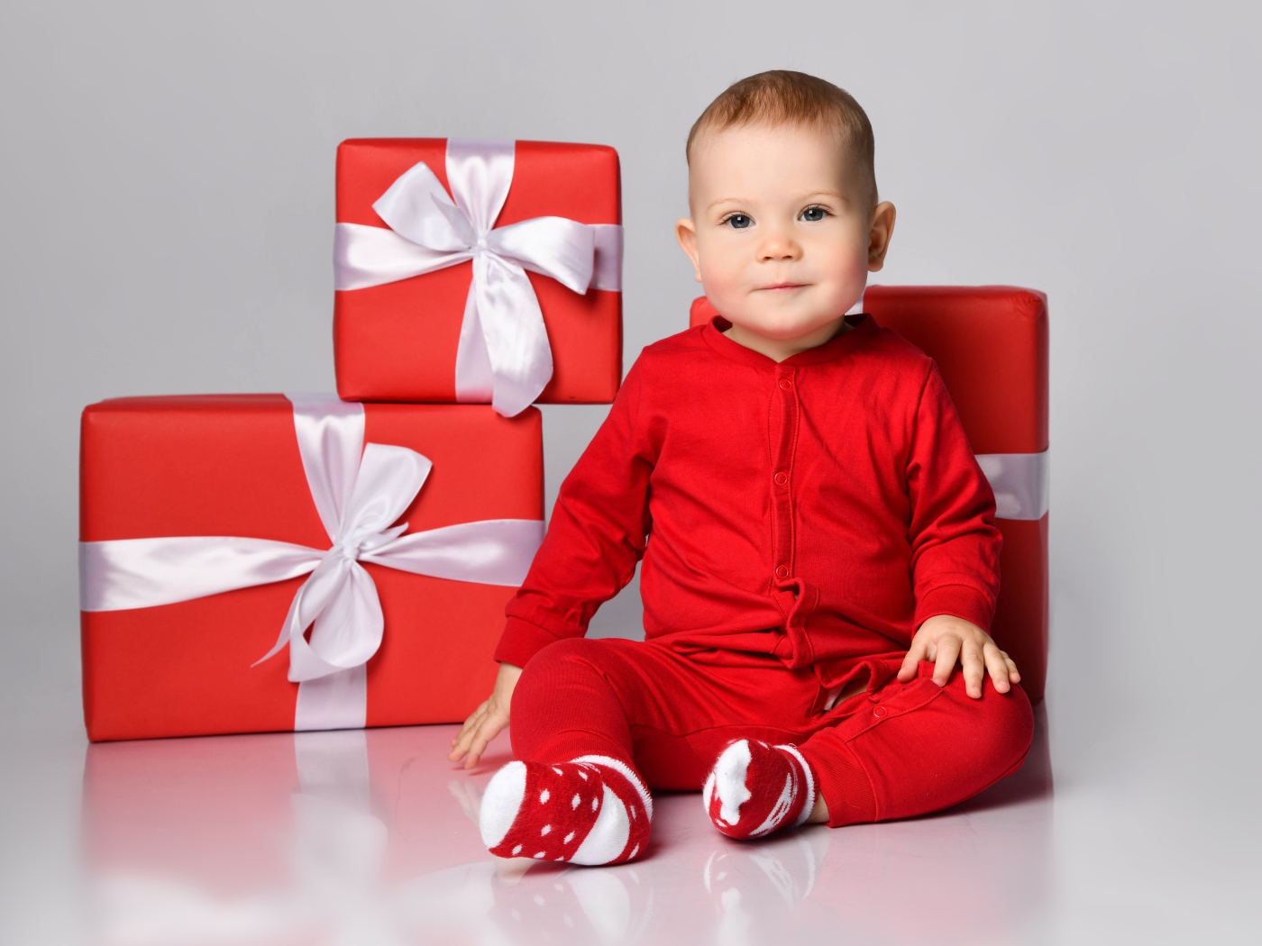 Маленький мальчик в красном костюме с подарками