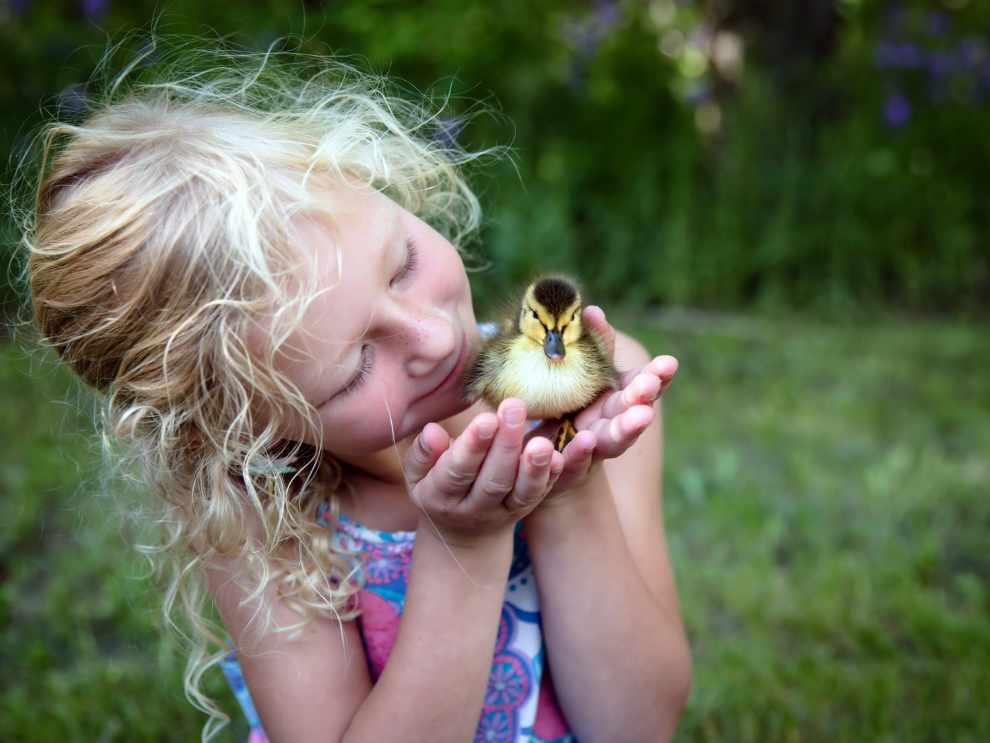 Маленькая милая девочка с утенком в руке