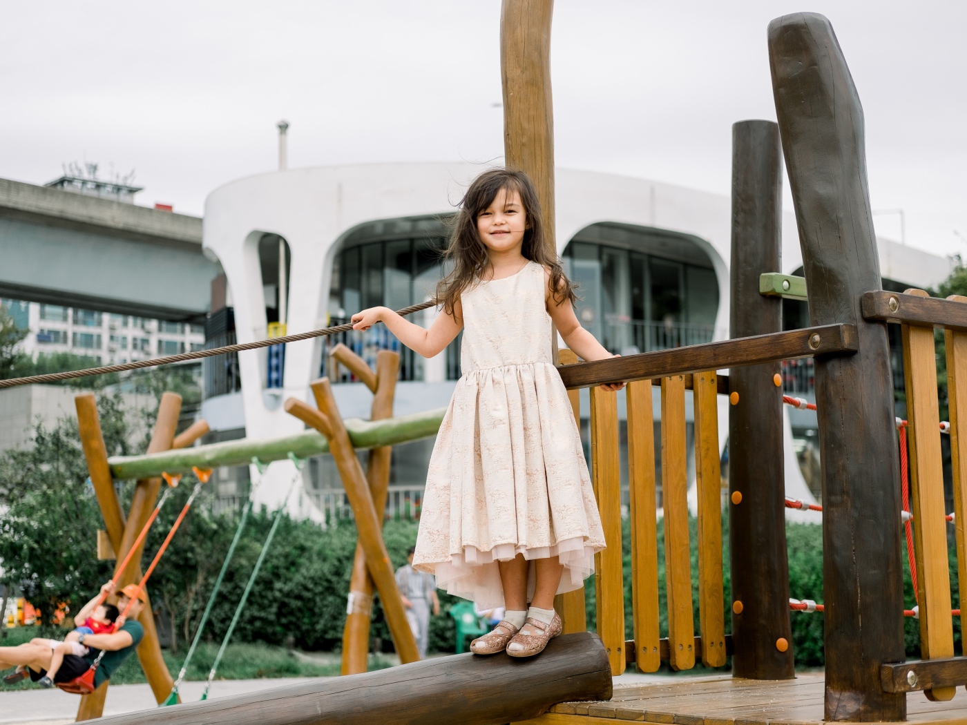 Маленькая девочка стоит на детской площадке 
