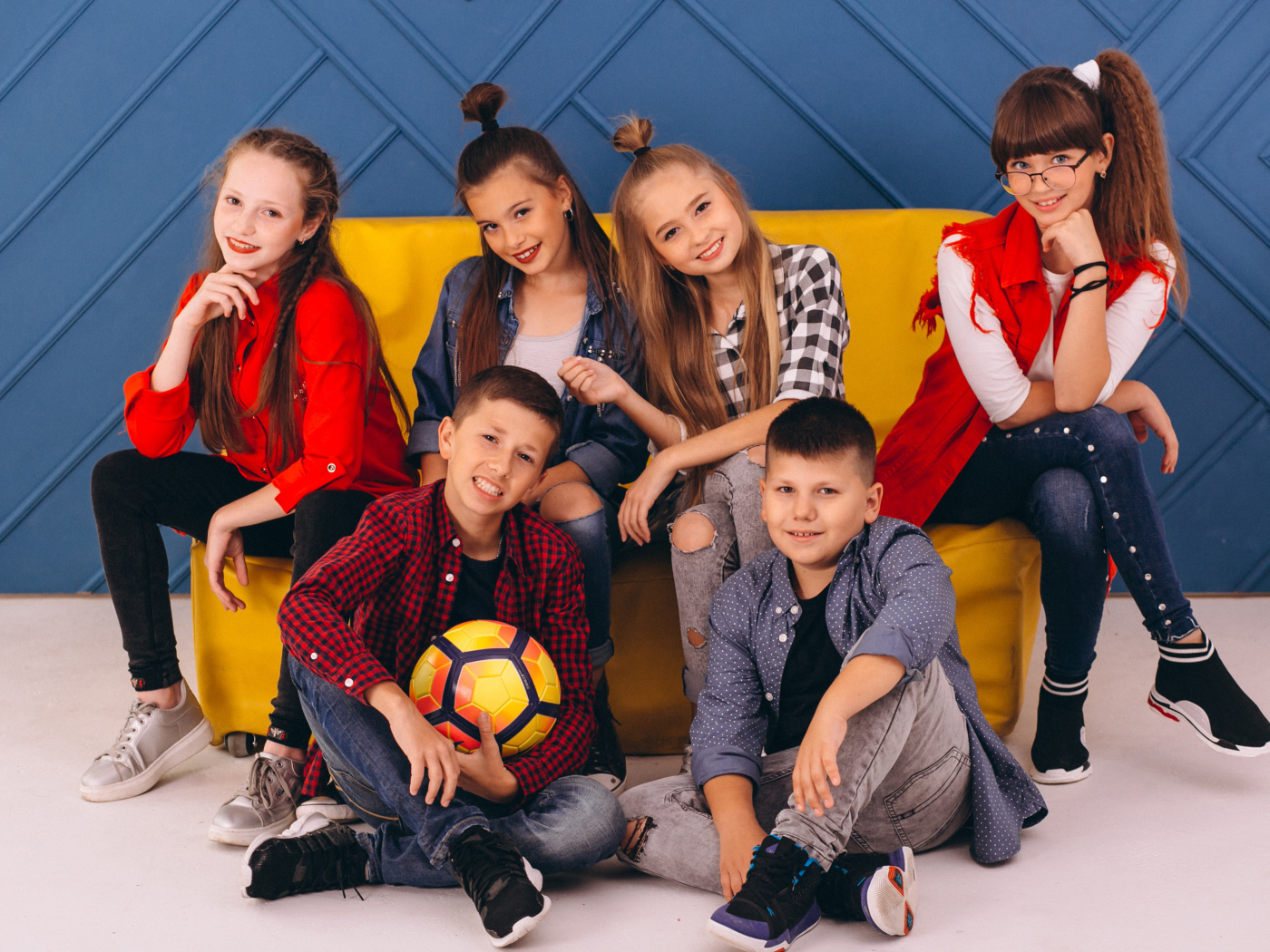 Много модных школьников сидят на диване