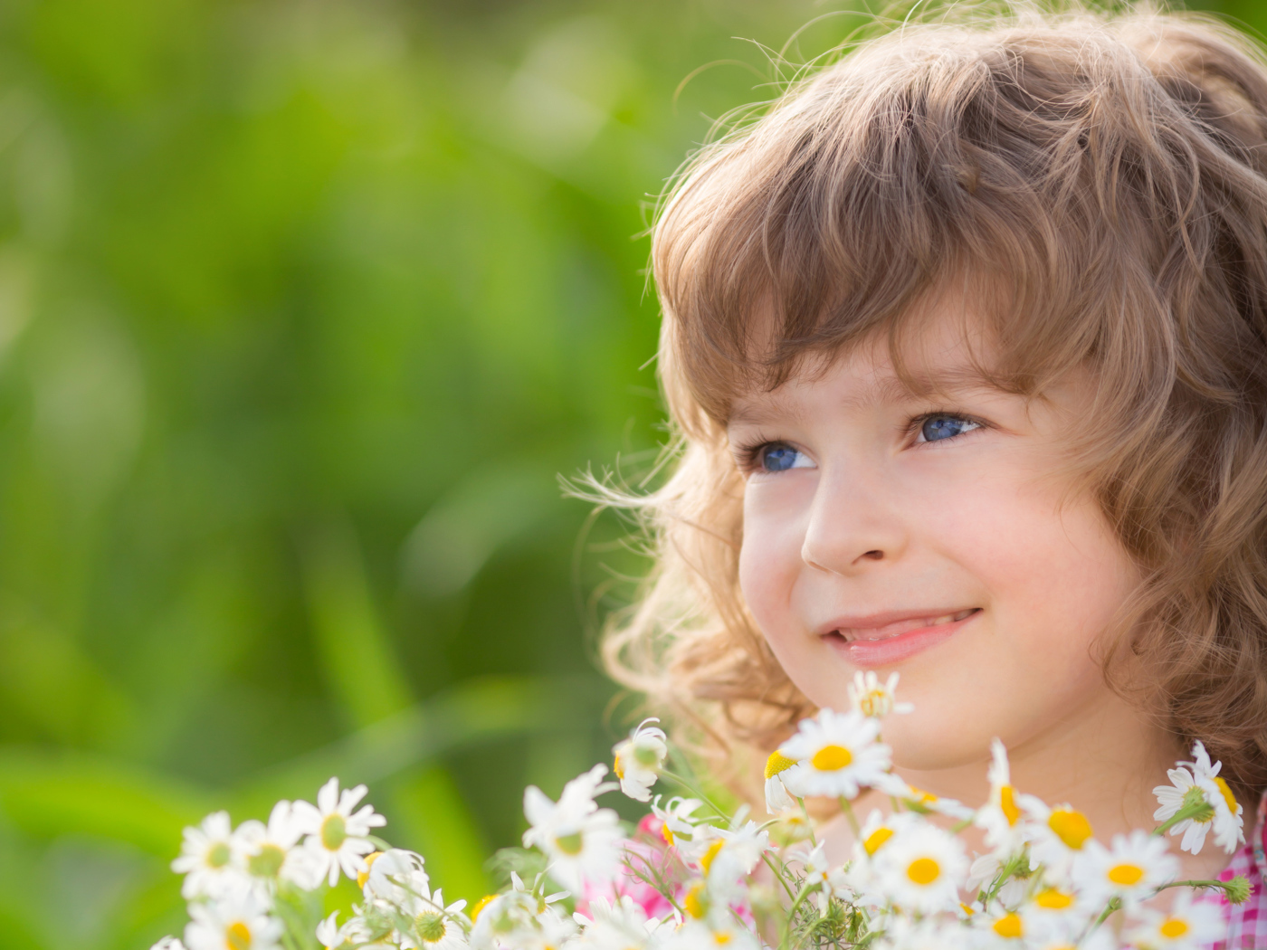 Улыбающаяся девочка с букетом ромашек 