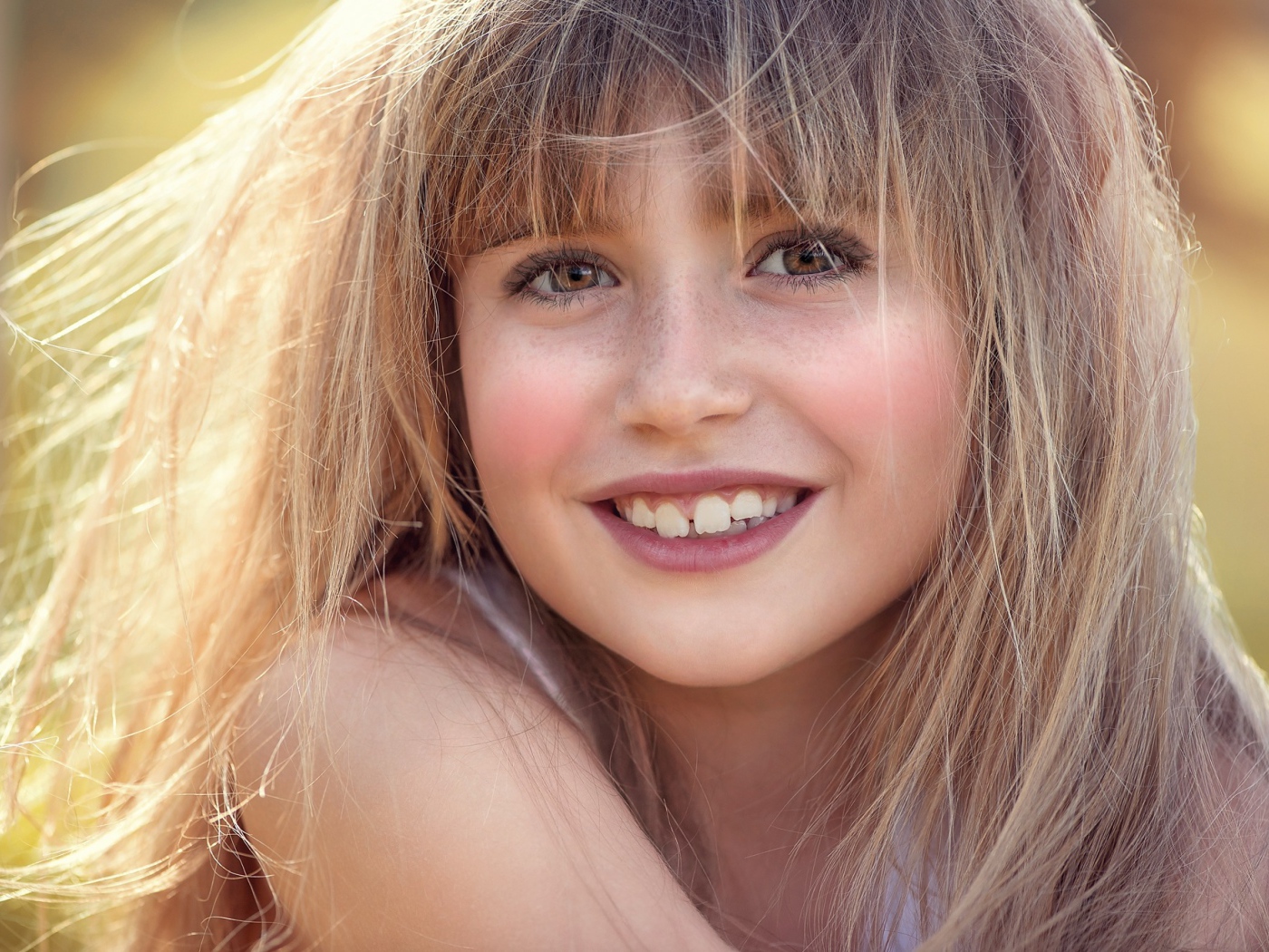 Улыбающаяся девочка с веснушками на лице 