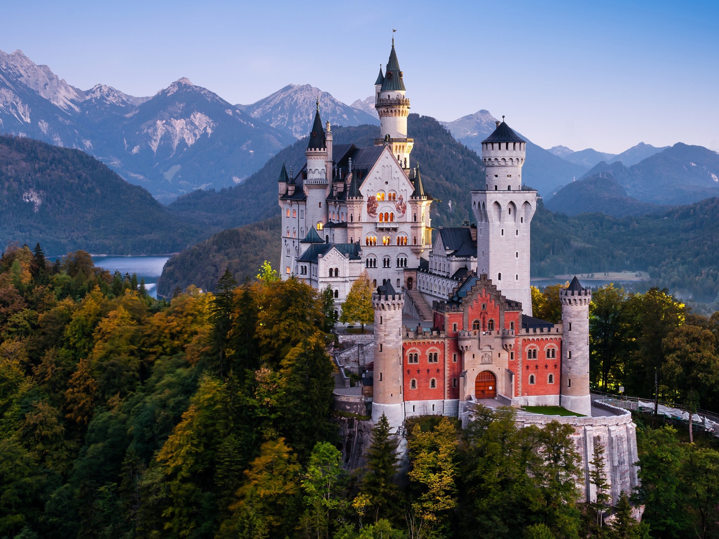 Замок Нойшванштайн в лесных зарослях на фоне гор, Германия 