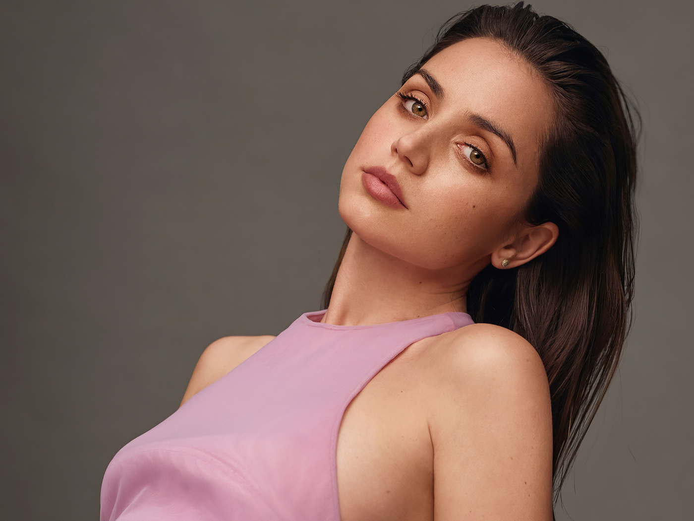 Actress Ana de Armas on a gray background in a pink sweater