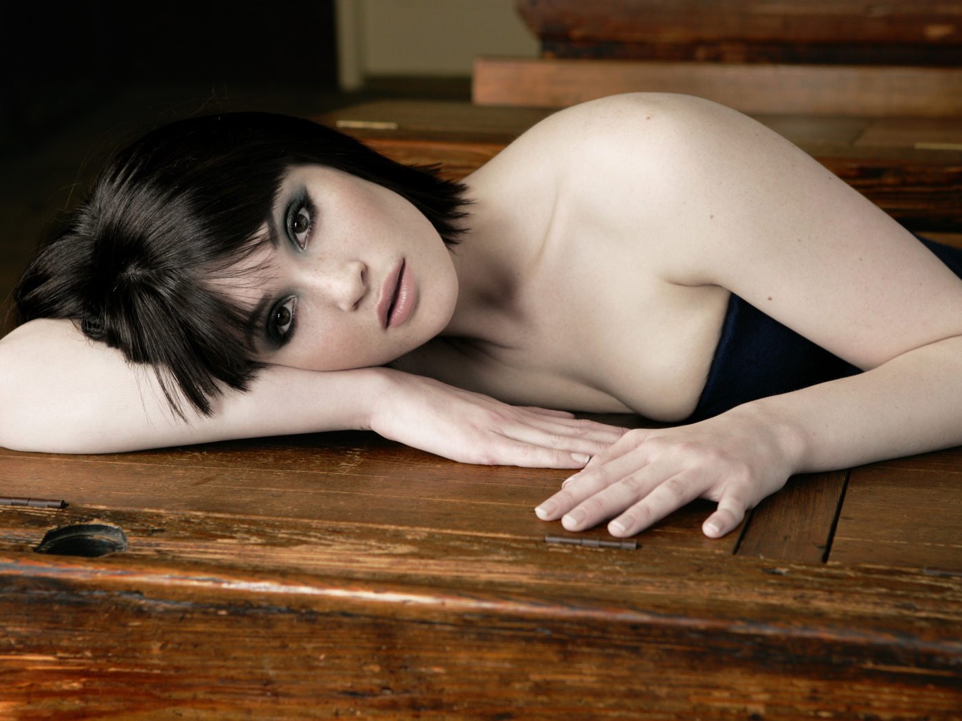 Актриса Джемма Артертон лежит на деревянном столе