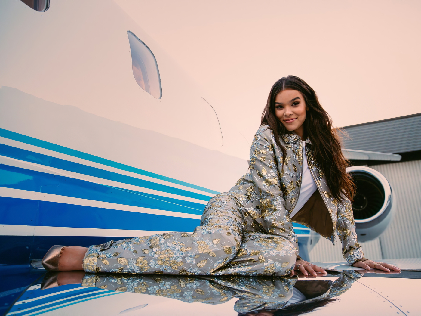 Актриса Хейли Стейнфилд в костюме лежит на крыле самолета